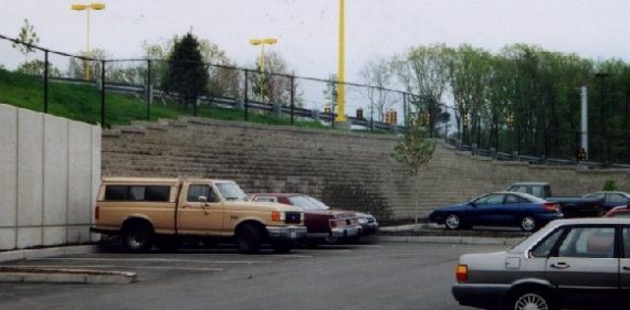 Retail parking area with segmental retaining wall abutting concrete panels