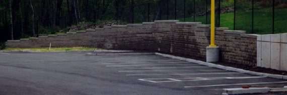 Segmental retaining wall abutting concrete panels